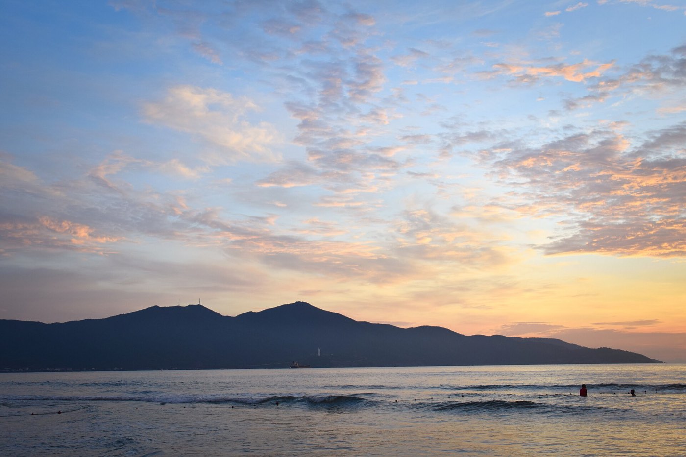 Sunrise over the sea at Da Nang, when the local swimmers are already in